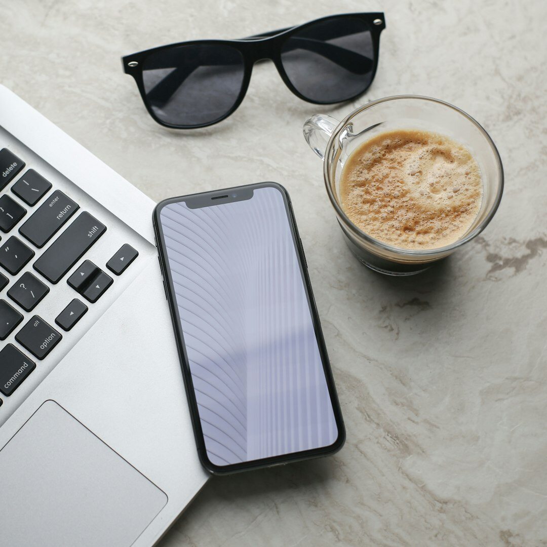 Top view of a desk workspace with laptop, notebook and coffee